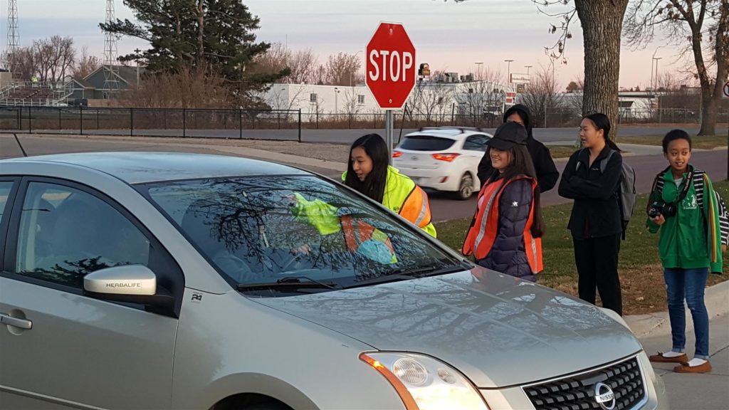 SADD members greeting drivers with Smarties and DumDums