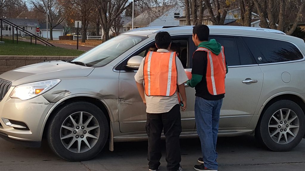 SADD members greeting drivers with Smarties and DumDums