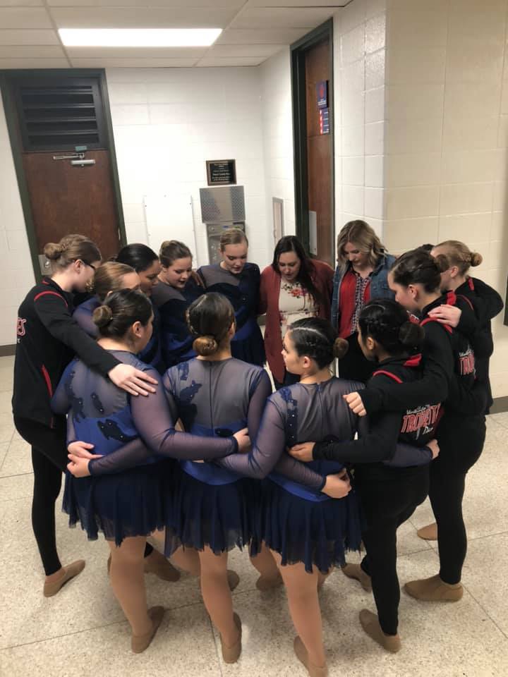 Dancers and coaches in huddle before competition