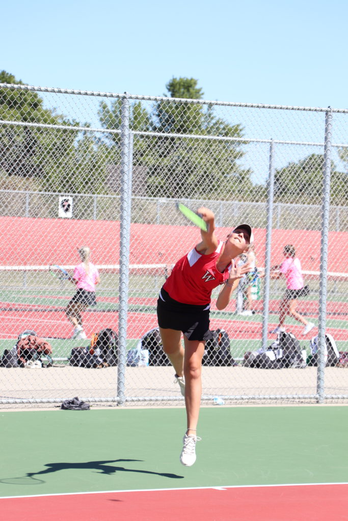 Trojan player going for the tennis ball