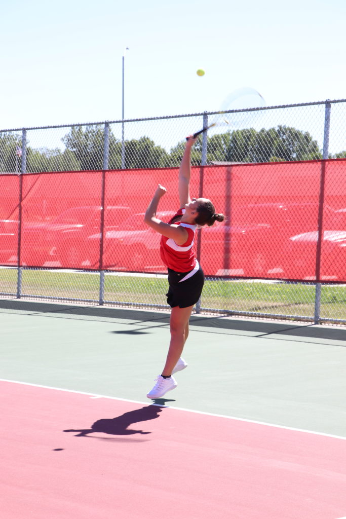 Trojan tennis player reaching high