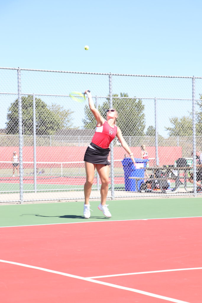 Trojan tennis player looking up at the ball