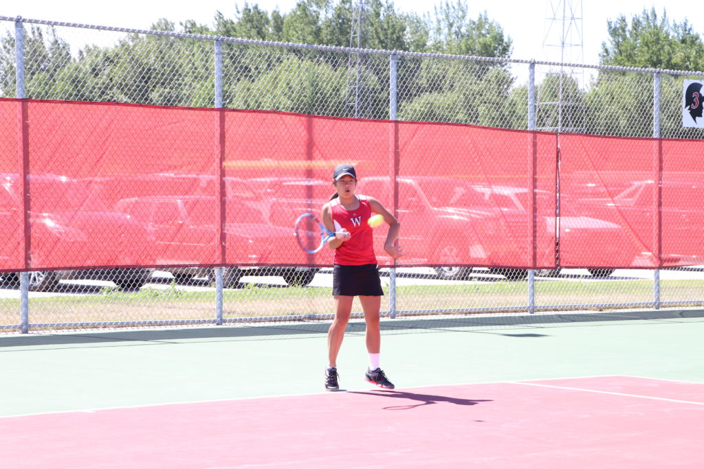 Trojan tennis player swinging