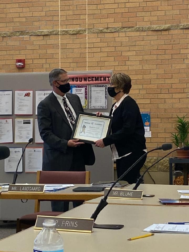 DeeAnn Crull receiving her award from Superintendent Landgaard at the school board meeting.