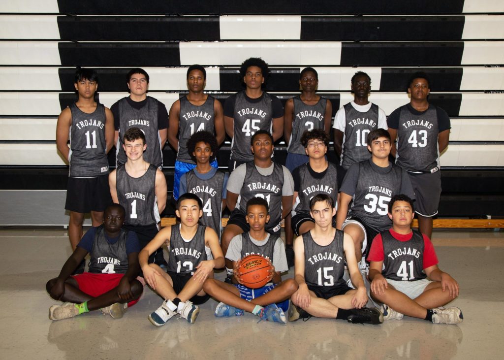 17 players wearing black jerseys lined up in three rows