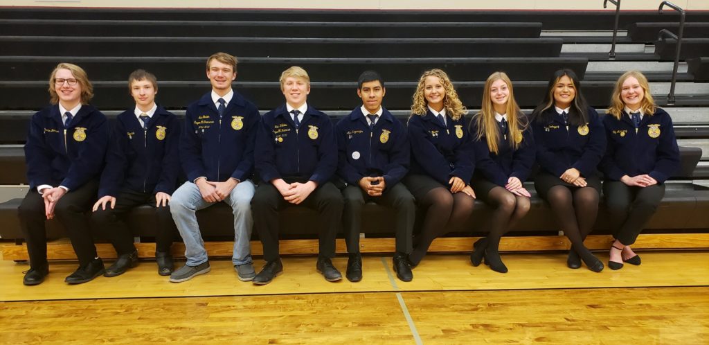 FFA students wearing FFA jackets sitting on bleachers