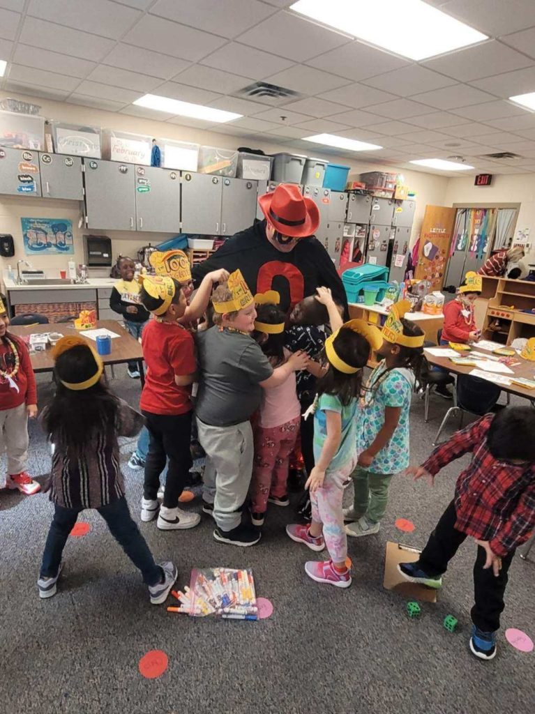 Zero the Hero getting hugs from students