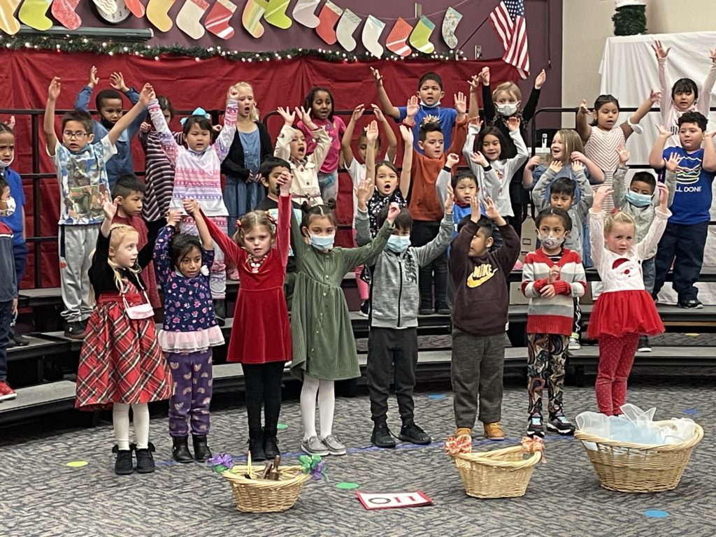 Student singing with arms raised