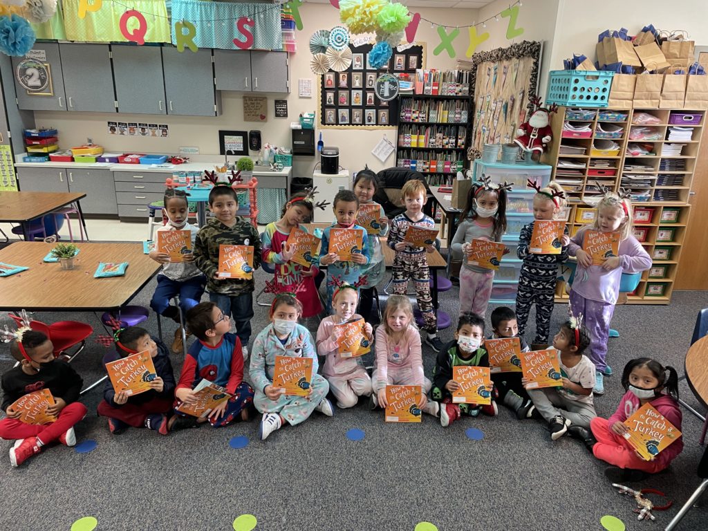 Students dressed in pajamas holding books