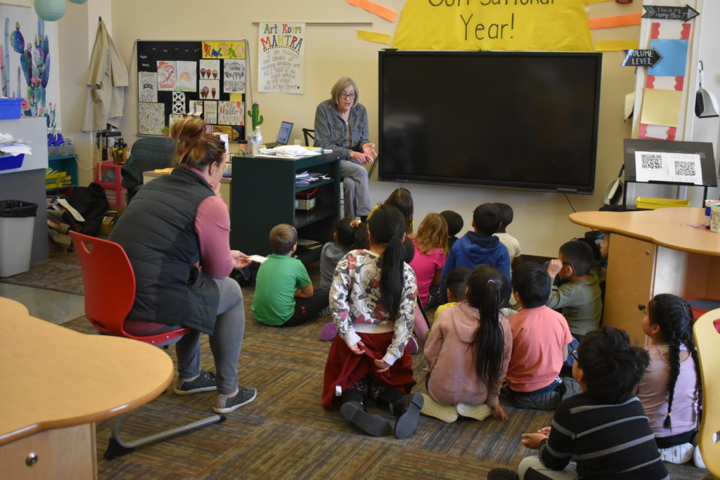 artist Bobbie Alsgaard-Lien  explaining to a group of students sitting on the carpet