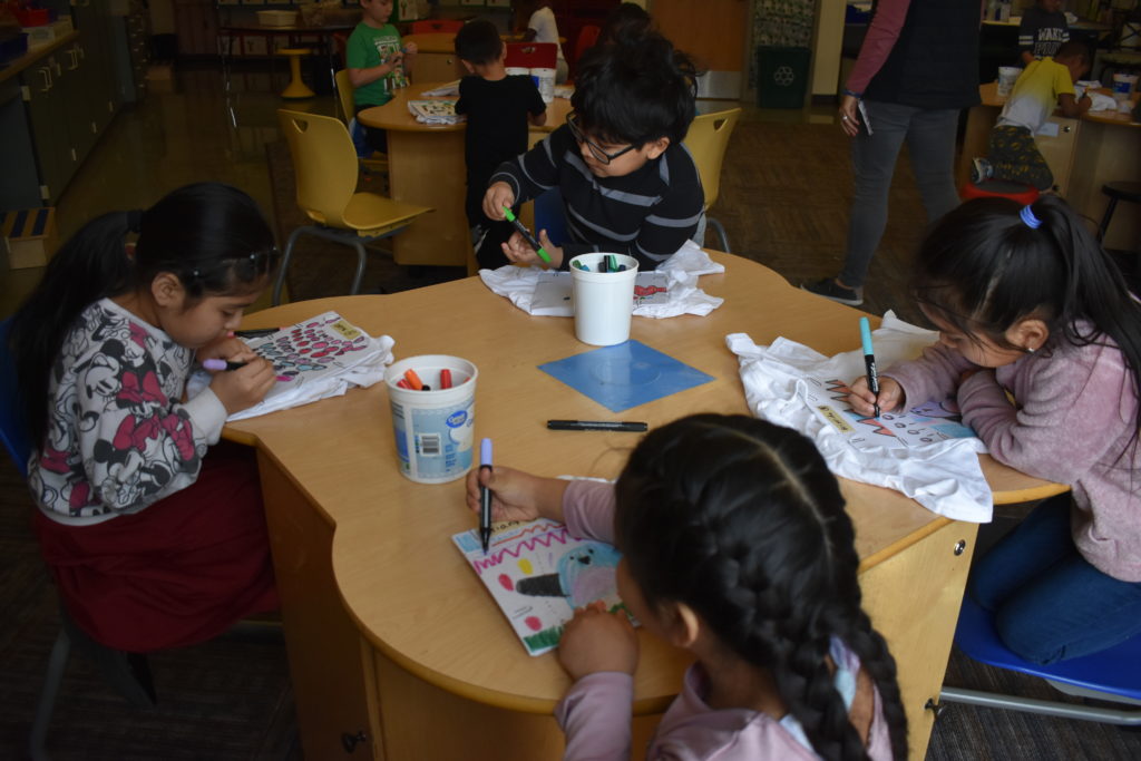 students at a table coloring