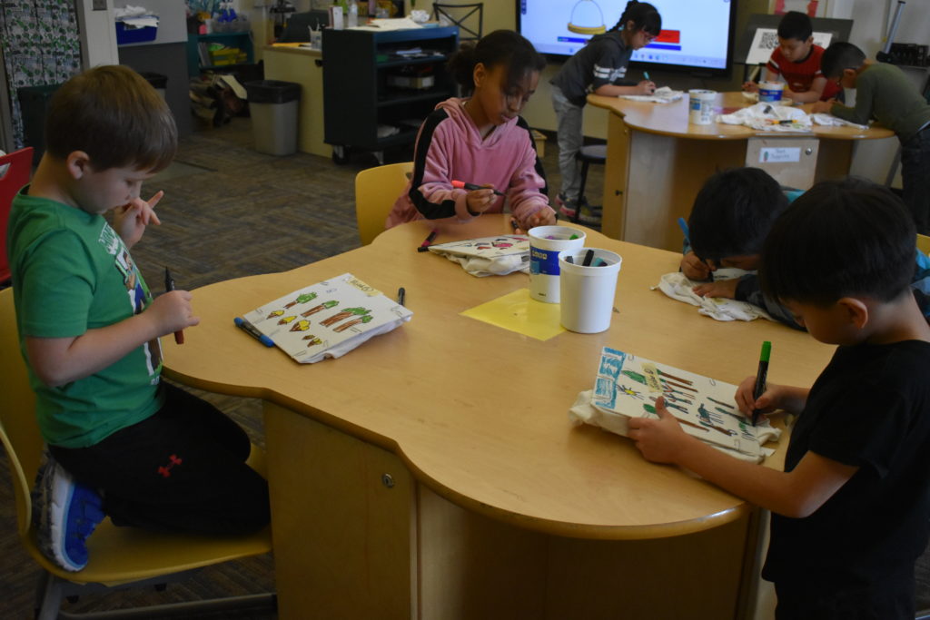 Girl by herself at a table coloring