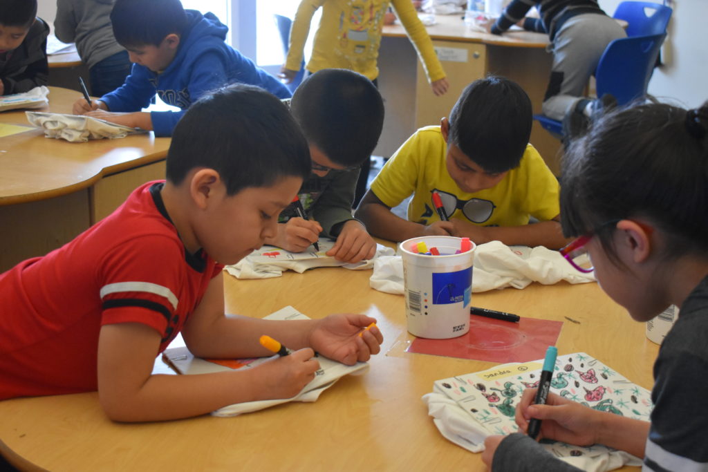 3 students coloring at a table