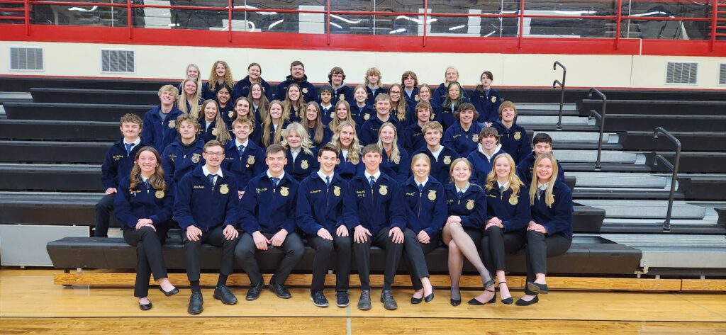 Students wearing FFA jackets sitting on the bleachers