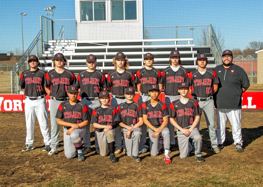 12 youth in baseball uniforms with the coach