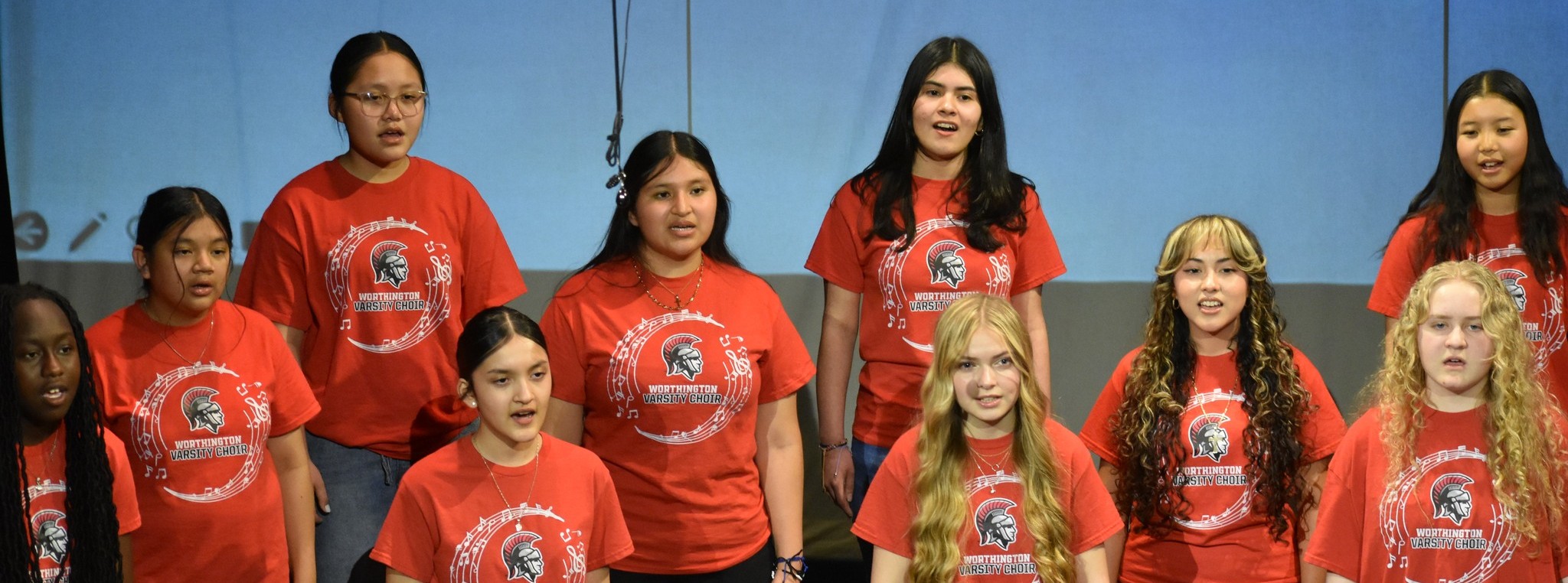 Students in red t-shirts singing