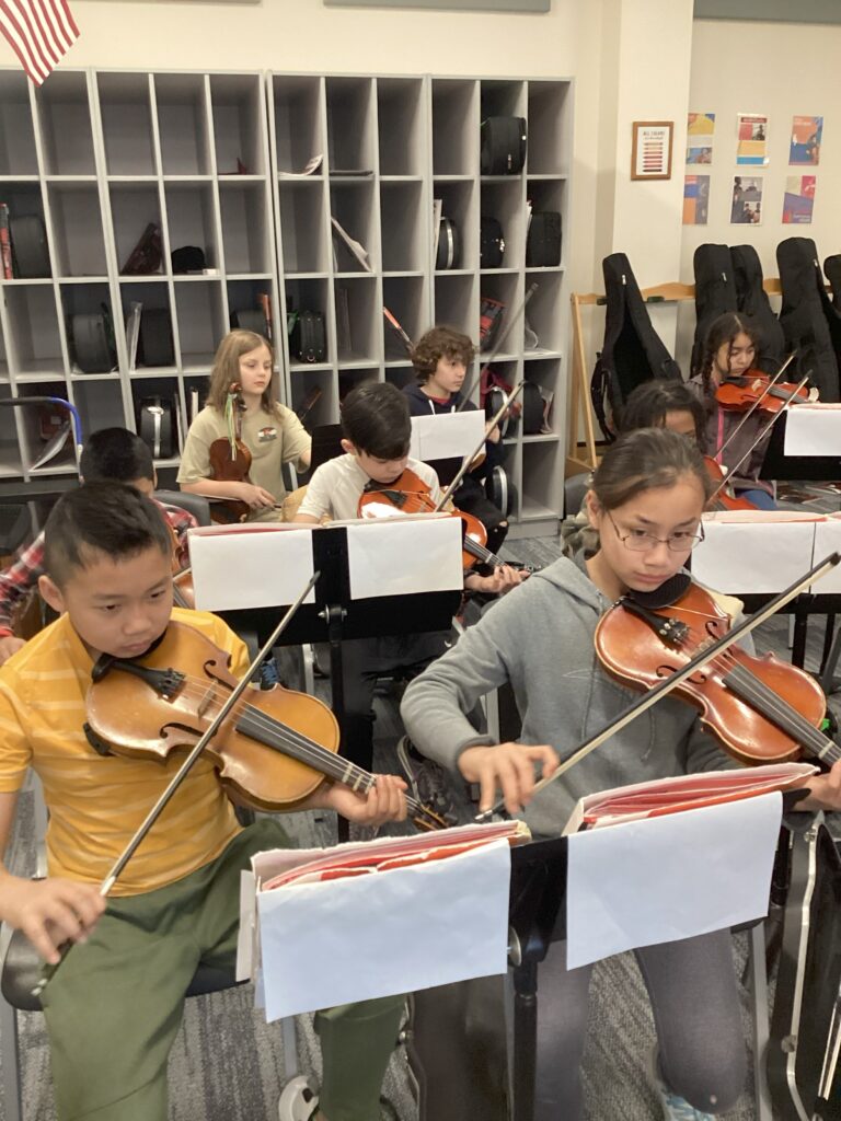 2 students playing violins