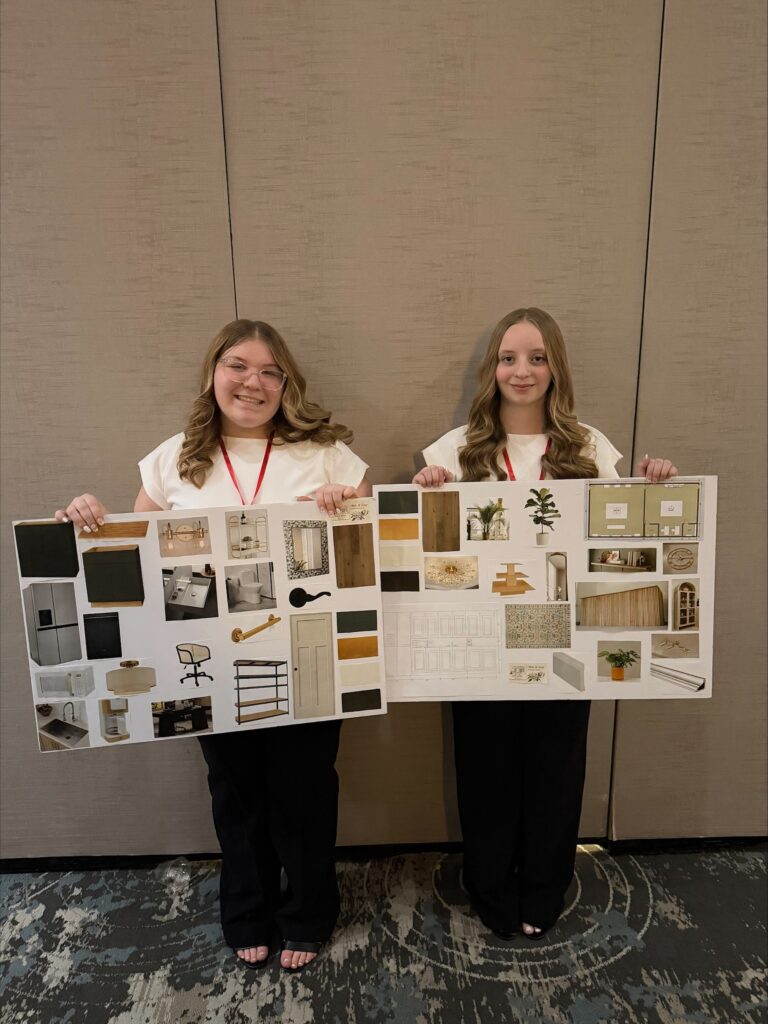 2 students holding design boards