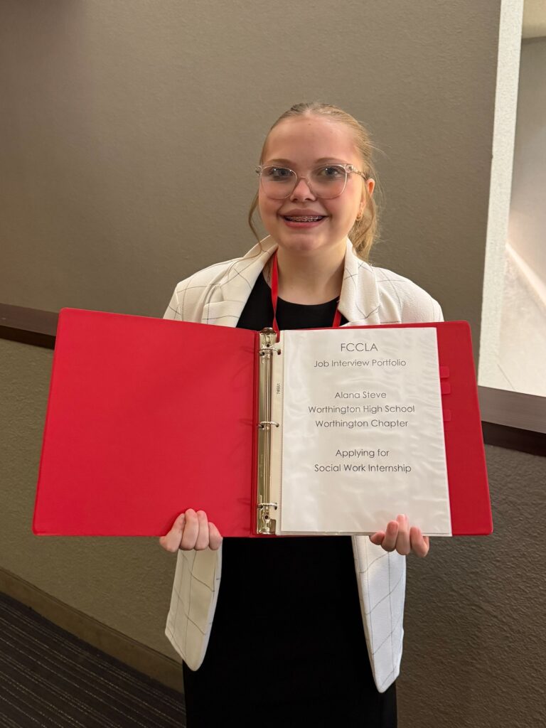 Student holding binder titled Job Interview Portfolio